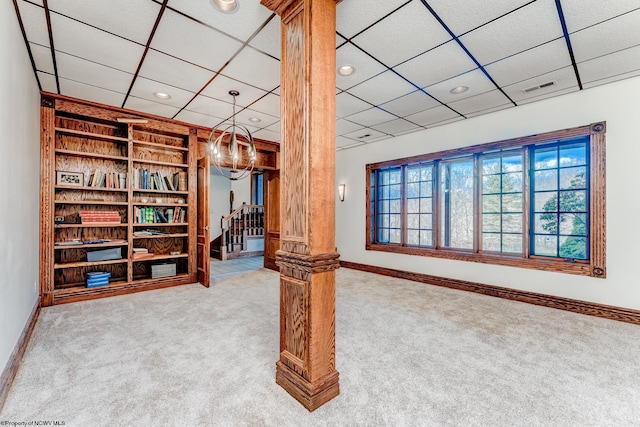 carpeted living room with a paneled ceiling and ornate columns