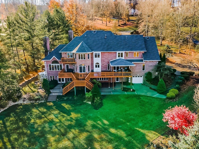 back of house featuring a wooden deck and a lawn