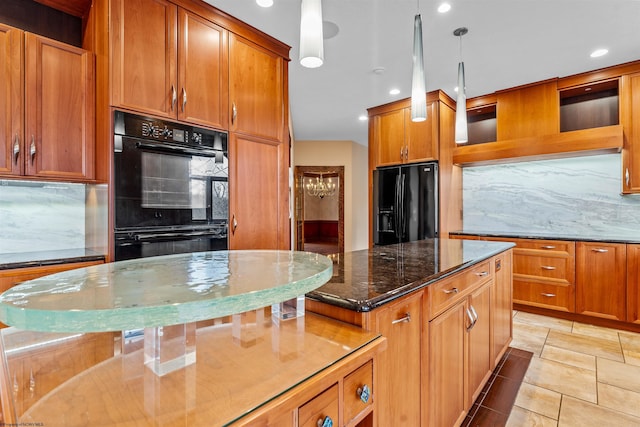 kitchen with pendant lighting, backsplash, a center island, black appliances, and dark stone counters