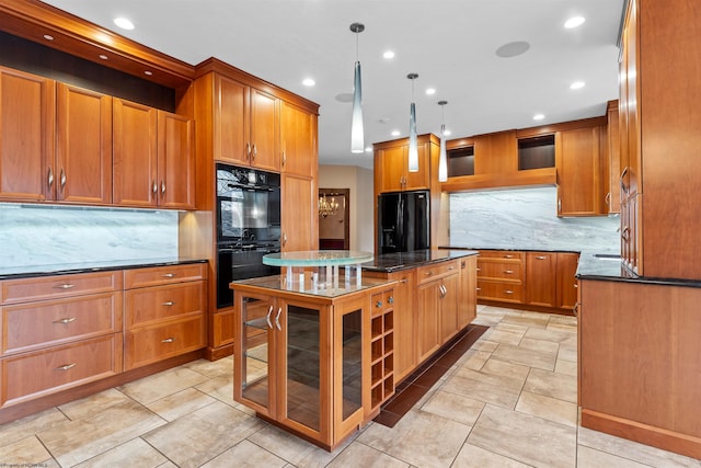 kitchen featuring decorative light fixtures, a kitchen island, dark stone counters, decorative backsplash, and black appliances