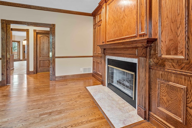 unfurnished living room with ornamental molding and light wood-type flooring