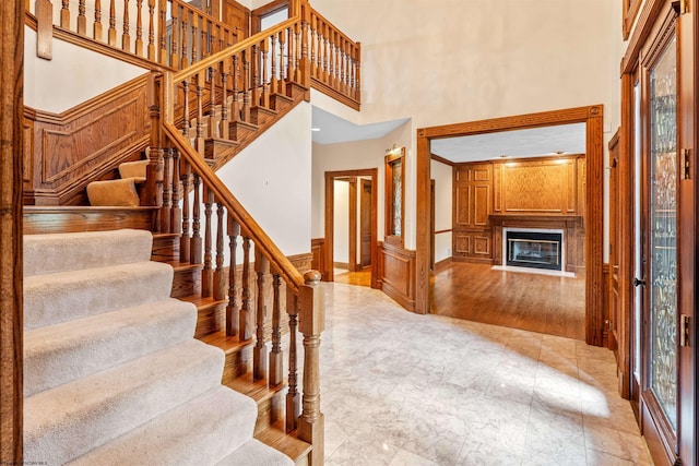 staircase with a high ceiling and wood-type flooring