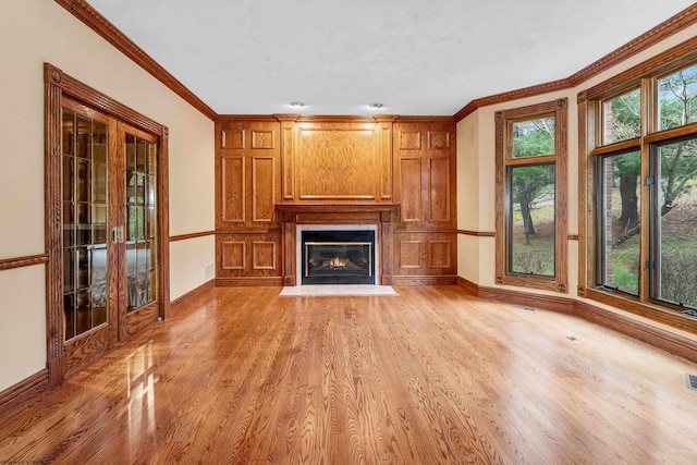 unfurnished living room with ornamental molding and light hardwood / wood-style floors