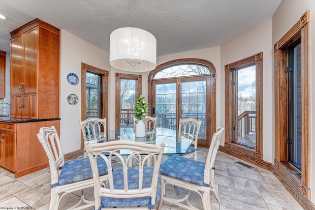 dining space featuring light tile floors and a textured ceiling