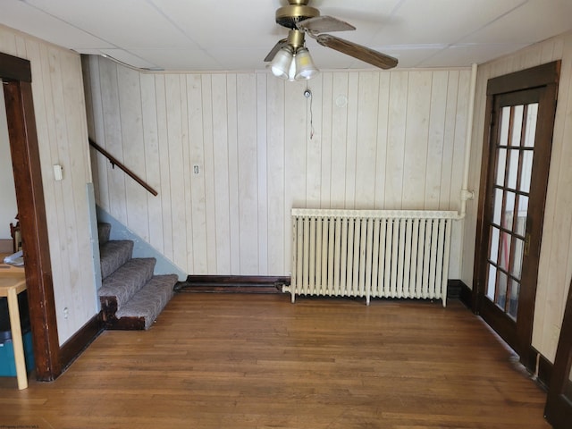 unfurnished room with ceiling fan, dark hardwood / wood-style floors, and radiator