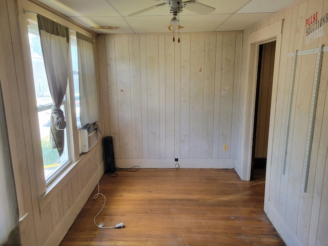 empty room with a paneled ceiling, dark hardwood / wood-style floors, and ceiling fan