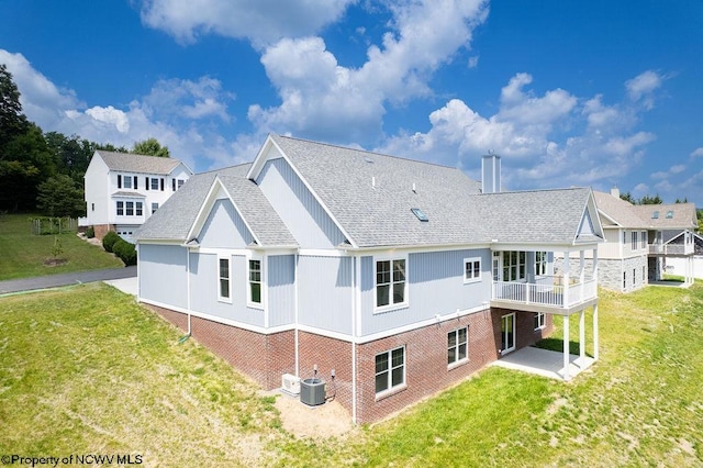 rear view of property featuring central AC unit and a lawn