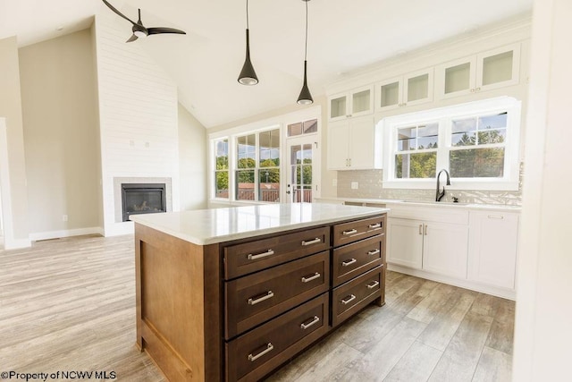 kitchen with white cabinets, backsplash, and light hardwood / wood-style flooring