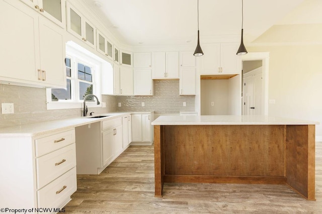 kitchen featuring light wood-type flooring, sink, a center island, and tasteful backsplash