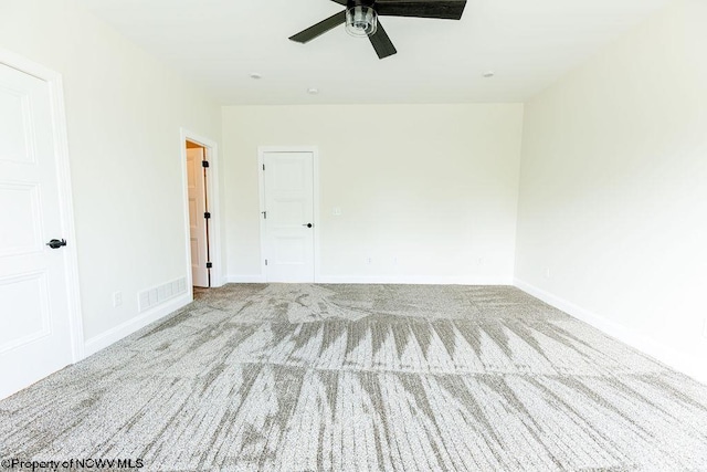 carpeted spare room with ceiling fan