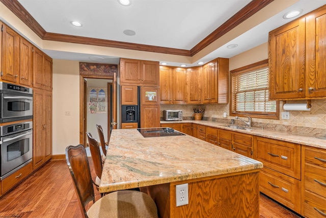 kitchen featuring light hardwood / wood-style floors, black electric cooktop, and tasteful backsplash