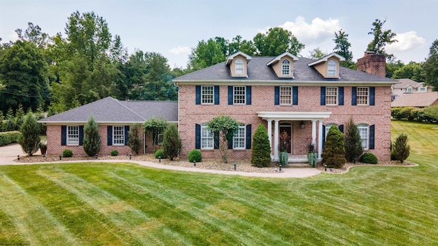 colonial home featuring a front lawn