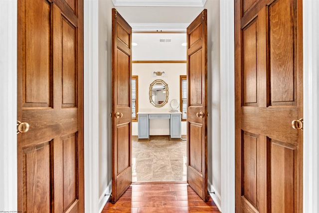 hall with light tile flooring and ornamental molding