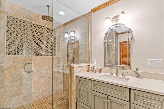 bathroom featuring ornamental molding, vanity, and an enclosed shower