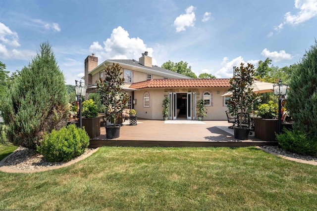 back of property featuring a yard and a wooden deck