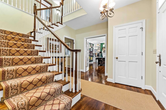 entryway with dark hardwood / wood-style floors and a chandelier