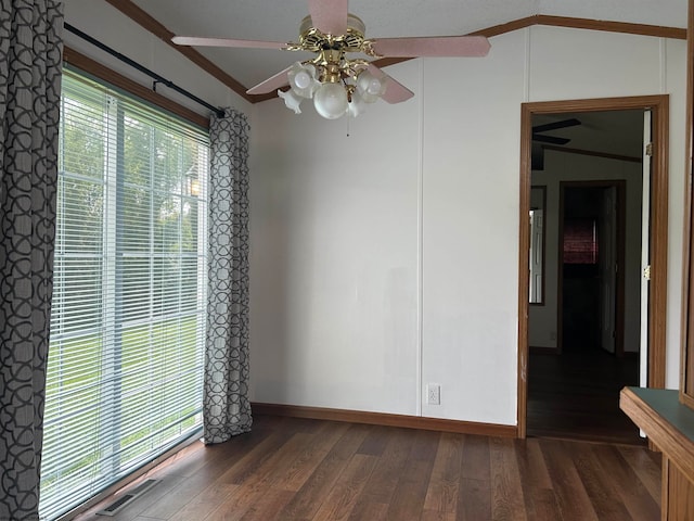 spare room featuring plenty of natural light, ornamental molding, ceiling fan, and dark wood-type flooring