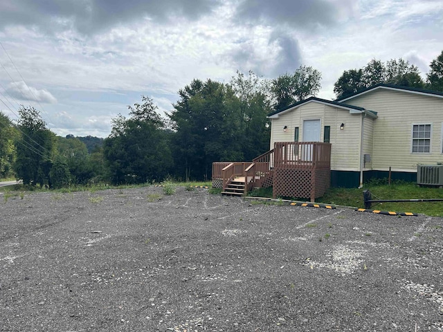 view of side of property featuring a deck and central AC unit