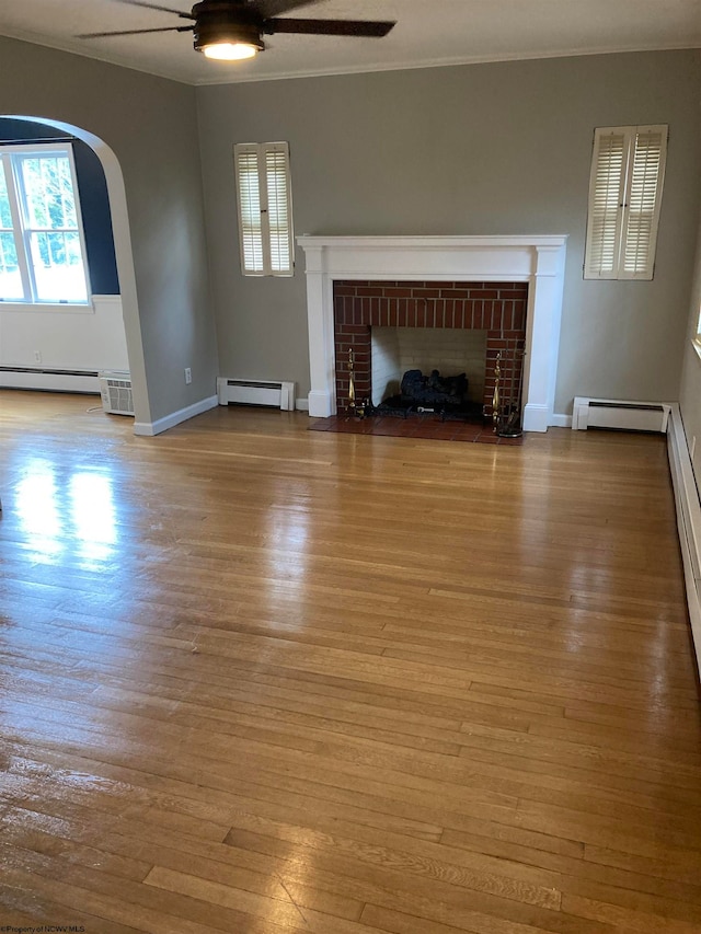 unfurnished living room featuring ceiling fan, light hardwood / wood-style flooring, a baseboard heating unit, and a fireplace