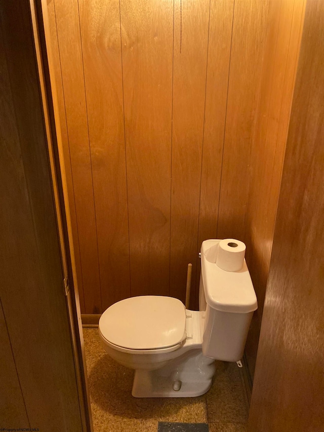 bathroom with wooden walls and toilet