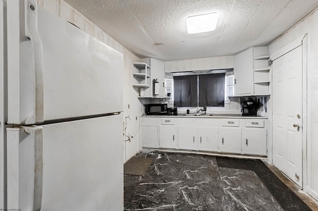 kitchen featuring white refrigerator, sink, white cabinetry, and tile flooring