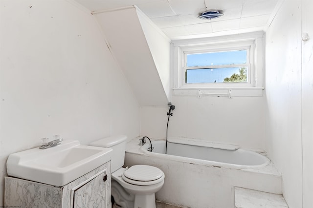 bathroom featuring vaulted ceiling, toilet, vanity, and a tub