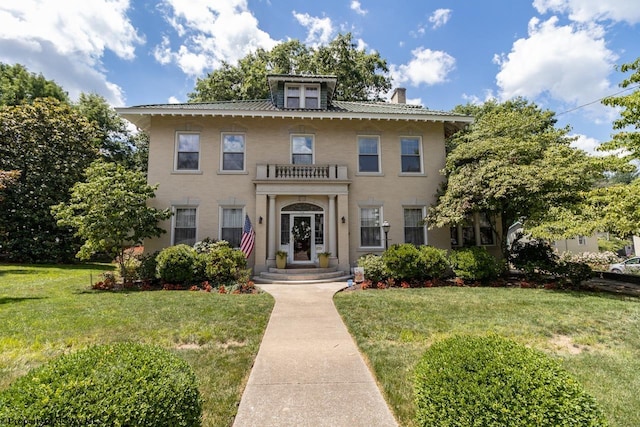 view of front facade with a front yard and a balcony