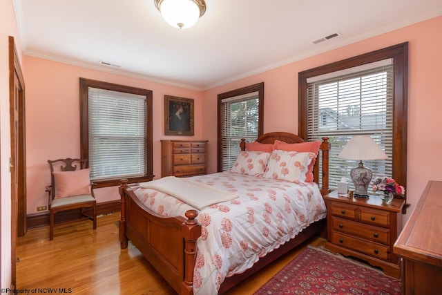 bedroom featuring hardwood / wood-style floors and crown molding