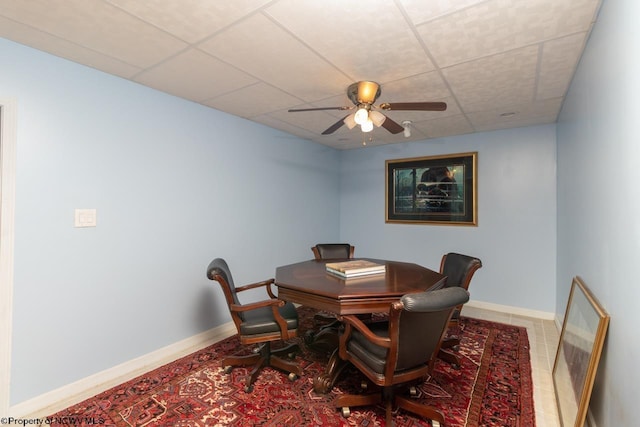 tiled dining space featuring a drop ceiling and ceiling fan