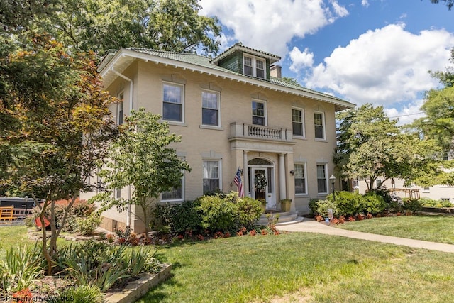 view of front of home with a balcony and a front yard