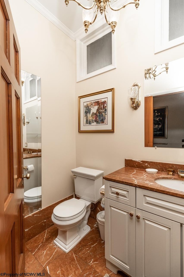 bathroom featuring tile flooring, vanity, toilet, and crown molding