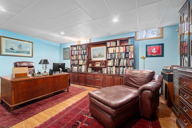 office with a drop ceiling and dark hardwood / wood-style flooring