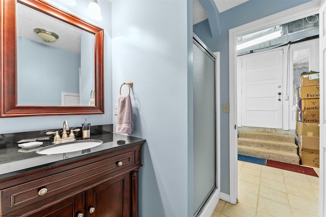 bathroom featuring an enclosed shower, vanity, and tile flooring