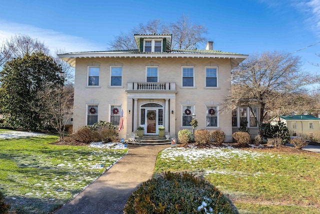 view of front of property with a front lawn and a balcony