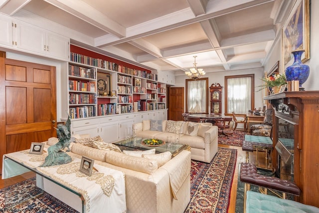 living area featuring built in features, beam ceiling, coffered ceiling, hardwood / wood-style floors, and an inviting chandelier