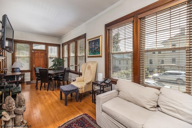 living room featuring a healthy amount of sunlight, hardwood / wood-style flooring, and crown molding