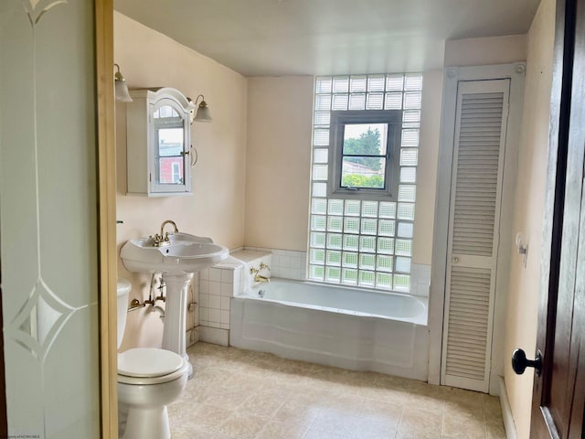 bathroom with toilet, a washtub, and tile patterned flooring