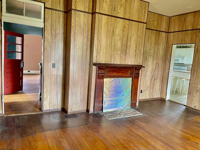 unfurnished living room with dark wood-type flooring and wooden walls