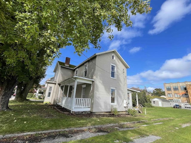 exterior space with a porch, a chimney, and a front yard