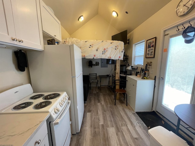 kitchen with plenty of natural light, white electric stove, white cabinetry, and vaulted ceiling