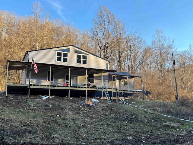 rear view of property featuring metal roof and a deck