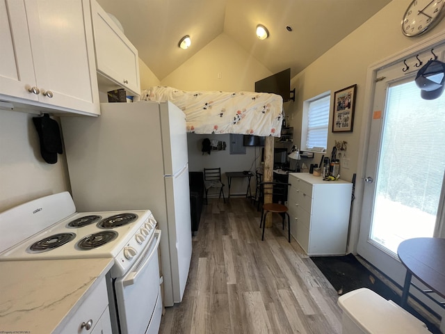 kitchen with wood finished floors, a healthy amount of sunlight, vaulted ceiling, electric stove, and white cabinets