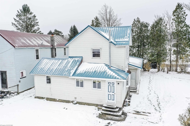 view of snow covered rear of property