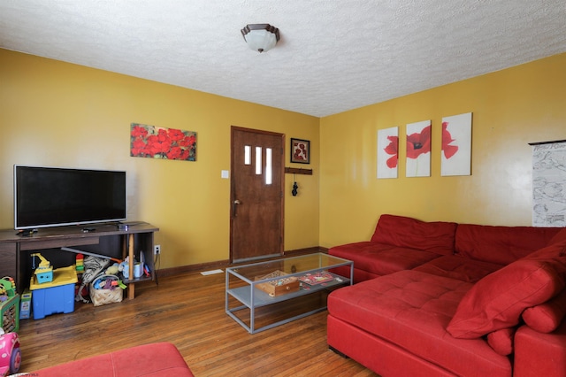 living room featuring a textured ceiling and hardwood / wood-style floors