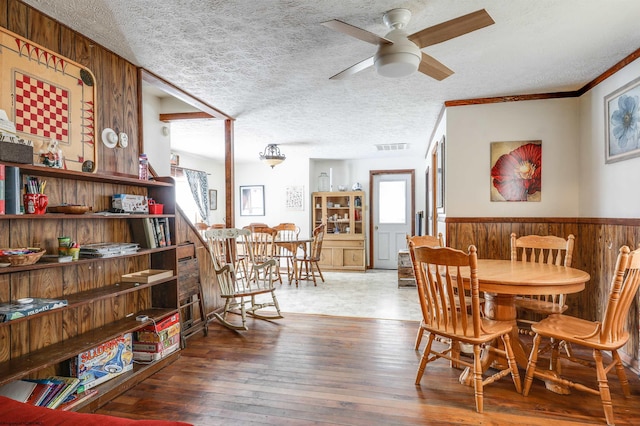 dining space featuring a textured ceiling, ornamental molding, ceiling fan, and dark hardwood / wood-style floors