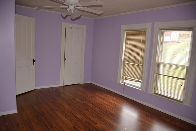 spare room with crown molding, ceiling fan, and dark hardwood / wood-style flooring