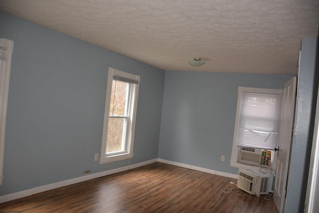 spare room featuring dark hardwood / wood-style flooring and a textured ceiling