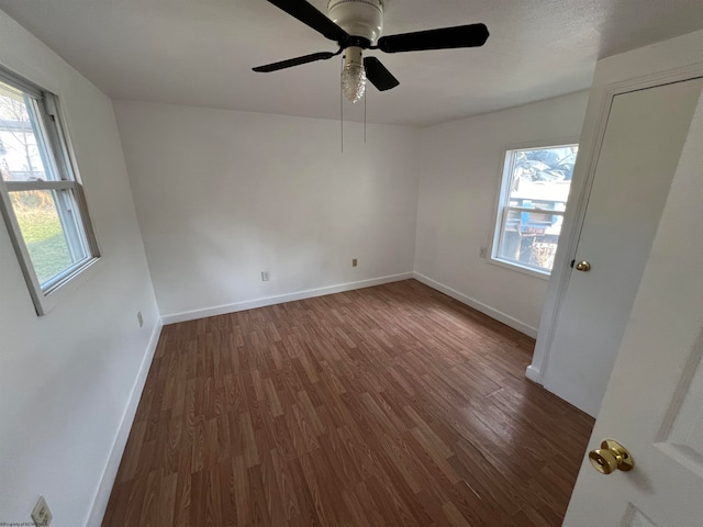 unfurnished room with ceiling fan, dark hardwood / wood-style flooring, and a healthy amount of sunlight