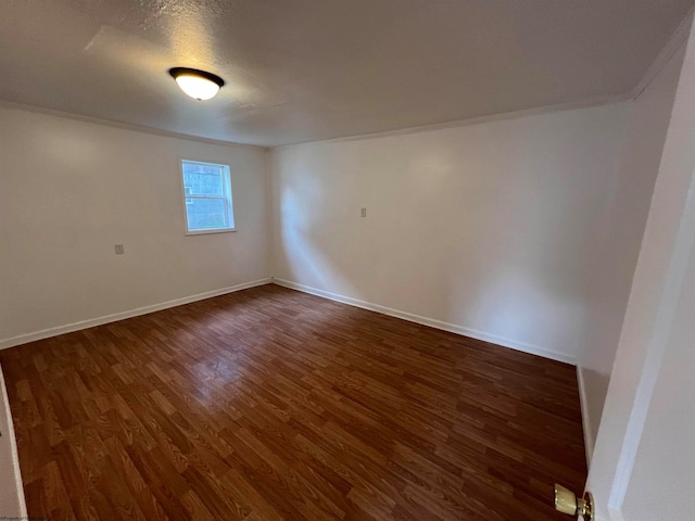 empty room featuring dark hardwood / wood-style floors and crown molding