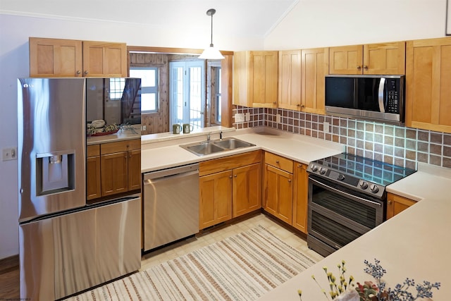 kitchen featuring sink, crown molding, appliances with stainless steel finishes, hanging light fixtures, and decorative backsplash